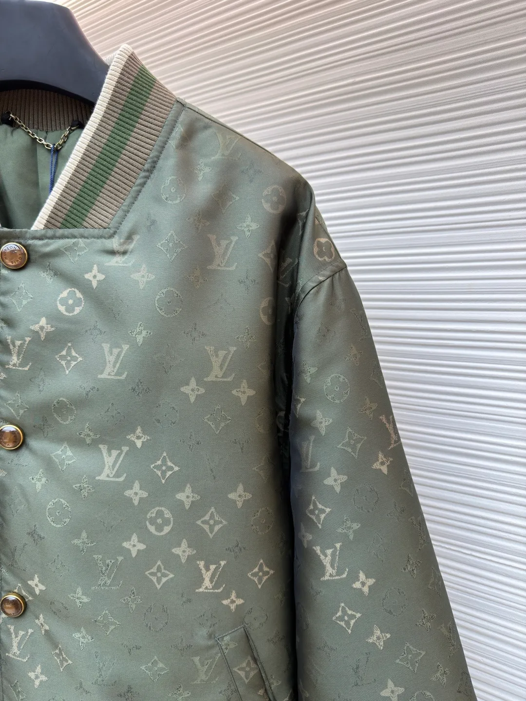 LOUIS VUITTON striped trim jacquard long-sleeved bomber jacket ●Original version: purchased and developed by 29237 ●Item number: 1682087-C05 ●Fabric: nylon fabric ●Technology: jacquard production ●Color: green ●Version: fitted version ●Weight: about 800 grams ●Size: S-M-L-XL ●Description: This Louis Vuitton baseball jacket is made of high-density jacquard satin fabric. The base is a polyester fiber blended material with a military green matte texture. The classic Monogram presbyopia pattern is woven into the fabric in the form of dark patterns of the same color through a special weaving process. The pattern texture is three-dimensional and presents a delicate illusion luster with the angle of light. High-precision jacquard weaving technology is used in the process to ensure the integrity and delicacy of the pattern. The body adopts a single-row metal snap closure design. The metal buckles are matte and distressed to echo the color of the body. The ribbed collar, cuffs and hem are made of two-color knitting technology. The elastic ribs have both stiffness and comfort, and are pre-shrunk to prevent deformation. The overall cut is a loose oversize version, and the splicing uses a combination of flat seams and hemming techniques. The interior is supplemented by smooth overlock sewing. Every stitch is even and fine, which fully reflects the brand's exquisite garment production technology and detail control. The overall wiring is straight and delicate, the fabric is comfortable and soft, and the color is consistent without color difference. It can be matched with the same style to create a fashionable look and control various occasions. Customized accessories, complete with three standards, same style for men and women!